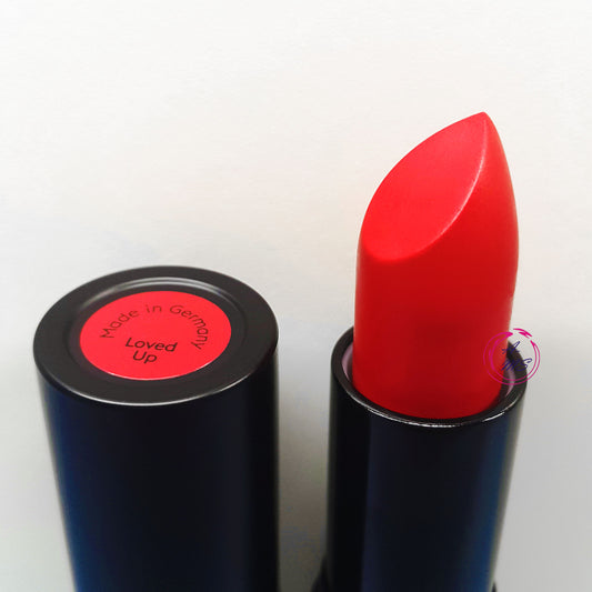 Red lipstick with black casing on a white background